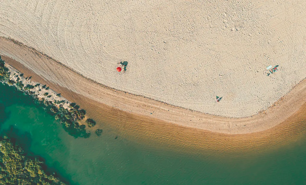 Vista aérea de uma praia da Arrábida, com águas cristalinas em tons turquesa