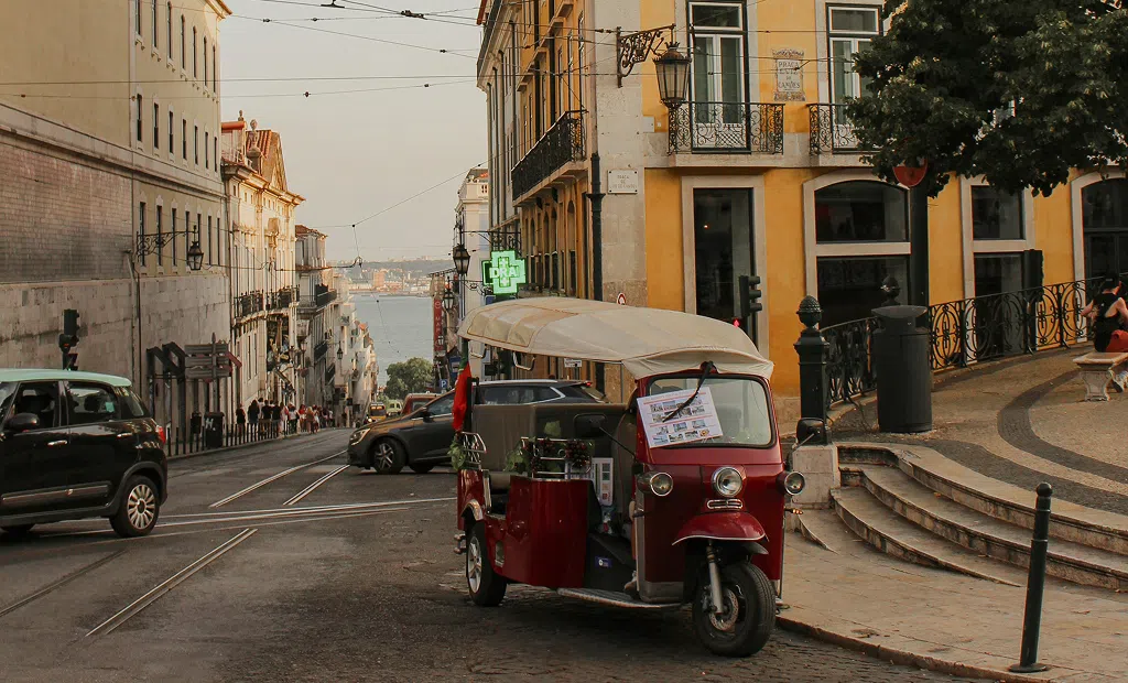 ua típica do centro histórico de Lisboa com um tuk-tuk